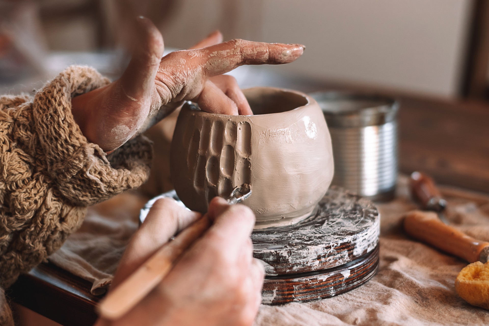 Female sculptor making clay mug in a home workshop,hands close-up.Small business,entrepreneurship,hobby, leisure concept